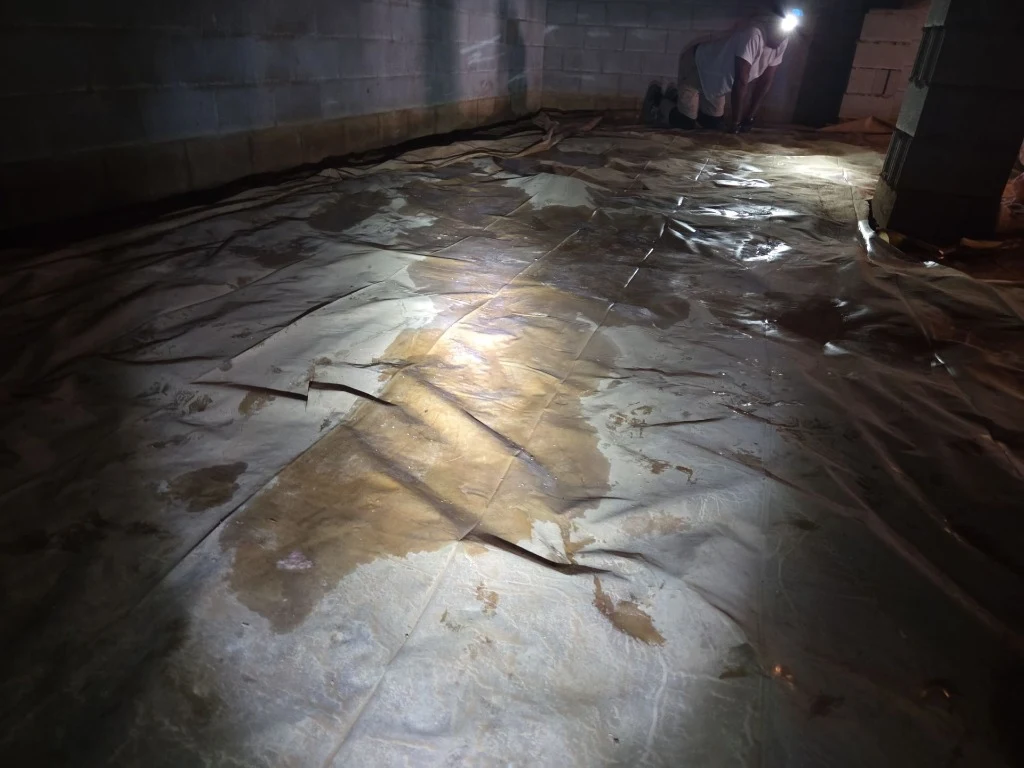 Standing water pooled on old vapor barrier during Somerset KY inspection