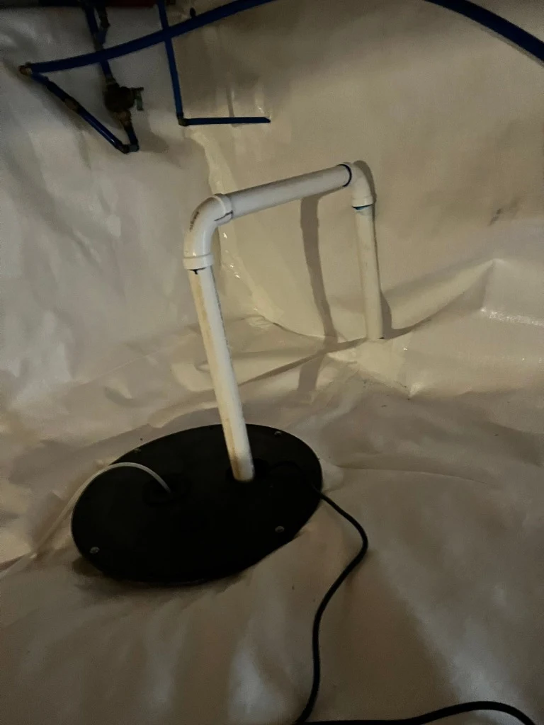 Airtight sealed sump pump basin and looped discharge pipe installed in sealed crawlspace